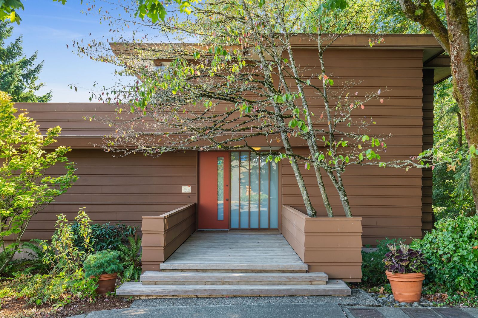 Architect Milton Stricker designed his 1967 residence with wood paneling, extensive built-ins, and a top-floor primary suite with a balcony.