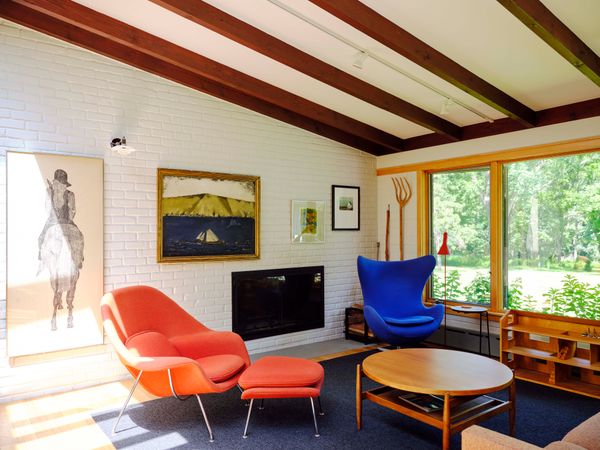 In the living room, a vintage Womb chair by Eero Saarinen and a vintage Egg chair by Arne Jacobsen face a 1960s coffee table by Risom. The side table is also by Risom, and the floor lamp is by Louis Poulsen. Beneath the window is a dollhouse built by Sven for Leah 35 years ago.