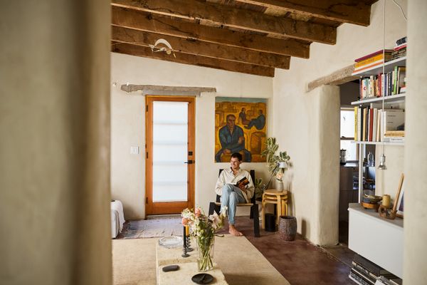 Photographer Logan Havens and designer Gustavo Silva restored an adobe in a Tucson neighborhood known for the structures, honoring the home’s original plan while layering in modern touches. In the living room, Logan sits in a lounge chair by Cade Manning Hayes of Dust Architects.