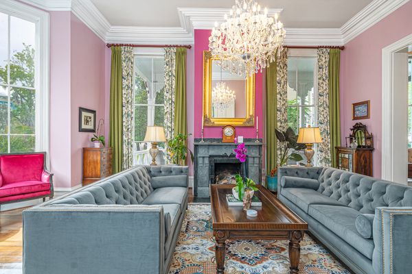 A large living room with an elaborate chandelier sits at the front of the house.