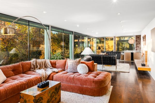 In the living room, wrap-around floor-to-ceiling windows blur the boundary between indoor and outdoor.