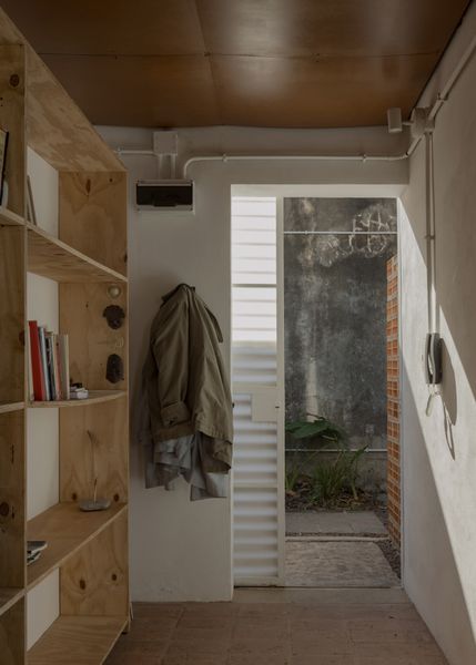 One of Este Norte’s founders, architect Daiana Katz, lives in the unit toward the front of the property closest to the entrance. A plywood built-in provides storage at her home’s entry.