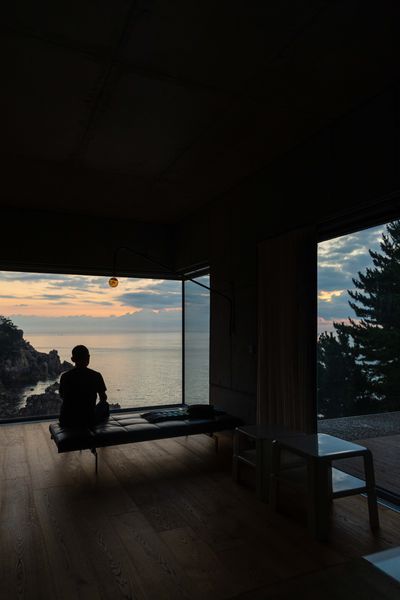 Architect Wook Choi watches the sea from the living room of the home he built with his wife, artist Jinnie Seo, in Goseong, South Korea.