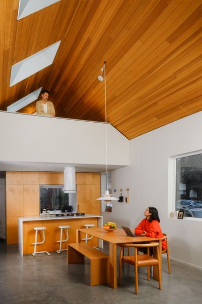 The compact kitchen consists of an island with Pitt burners and a wall of custom cabinetry by Niche Interior Designs. Concrete floors with radiant heating keep feet warm on cold mornings.