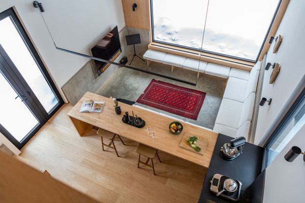 The open kitchen overlooks a sunken living area, where the polished concrete foundation doubles as a natural heater. 