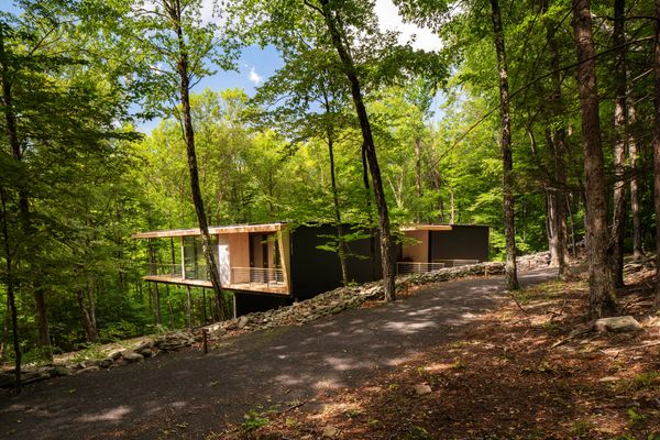 The home’s stained pine exterior blends in with the tree trunks, while its inner liner gives a sense of the warmth that awaits within. The couple found a piece of lichen on-site and had the home’s columns color matched to it.