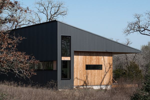 The triangular roof profile provides the structural depth needed for the cantilever while following the site’s natural slope.