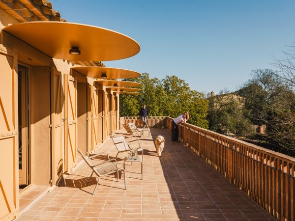 Miguel Lorán and Isabel Campos asked architects Anna and Eugeni Bach to renovate and expand their vacation home in the tiny medieval town of Fonolleres, Spain. Shifting the heart of the house to the outdoors, the Bachs added a broad balcony to the upper level, creating a portico below.