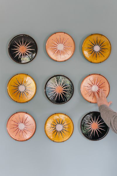 Leaning into the sheen of disco, Jacobsen developed a series of enameled copper plates with sun motifs.