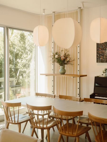 The living area doubles as a showroom for Isaac and Sydney’s new studio, Granada Form. A Slice table is surrounded by Boston chairs by Chilton, and behind them is a Peg shelving system. The Mori pendants are by RBW.