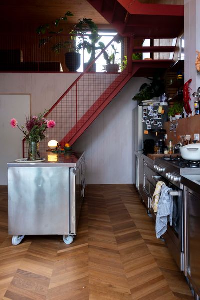 A vintage rolling island adds flexibility to the kitchen layout. The herringbone flooring is from Quick-Step.