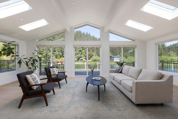 Existing windows and sliding doors on the north side of the house frame views of the Nestucca River. 