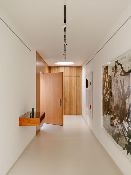 The entry of Andrea Guerra’s São Paulo home doubles as a gallery space. At the far end is her office, placed here in the floor plan so visitors wouldn’t have to come through the house.