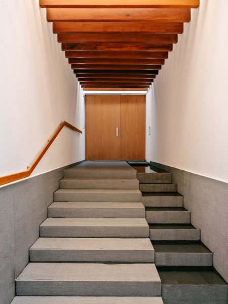 Rhythmic beams mark the threshold into the living areas.