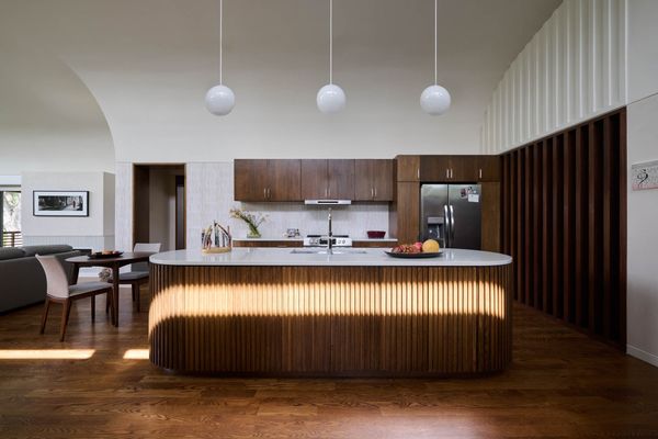 The living area, dining area, and kitchen sit at the heart of the plan—an interior core with no exterior walls of its own, lit instead from above through the lifted roof.