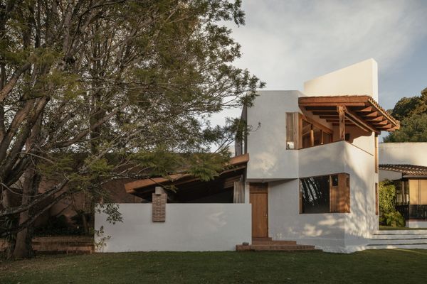 The thick wall that extends above the home’s second floor conceals water tanks that supply the two bathrooms below. Load-bearing walls were made from a combination of concrete blocks and red brick, with nonstructural adobe infill.