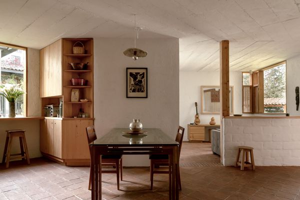 The ground floor has an open kitchen, dining area, and living area.  Constantino planned the layout to accommodate his mother’s needs in later years: by closing off the half wall seen in the background and adding a door, the space can be converted into a one-bedroom apartment. The upper floor could become an independent unit.