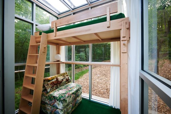 One of the cabins has a lofted bed and a seating area below. Sheers provide privacy to the interiors as needed.