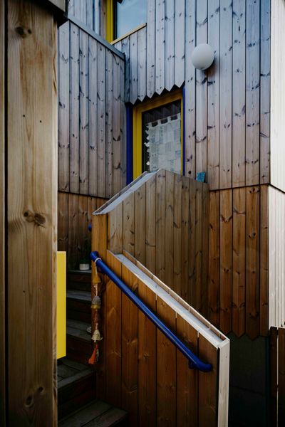 Yellow window frames brighten an ADU created by architect Ivan Kostic to replace a dilapidated garage next to his house in Seattle. Clad in Scots pine, the structure combines a new garage with a two-story rental unit.