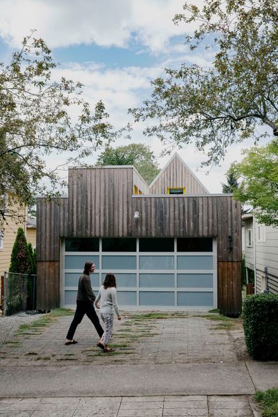 Current tenants Evan Fleming and Lenore Wan walk past a custom garage door from Precision Door Service. It has one row of clear glass and three rows of frosted. 