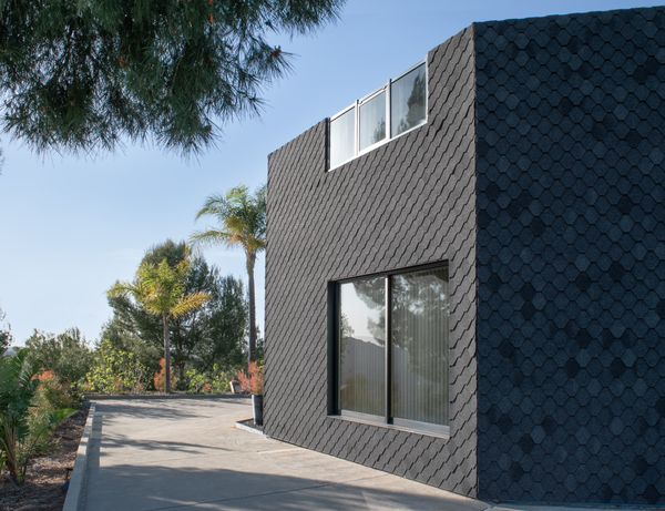 Pali and Fekete-Pali chose to clad the whole building in fire-resistant asphalt shingle, cut into robust hexagons.