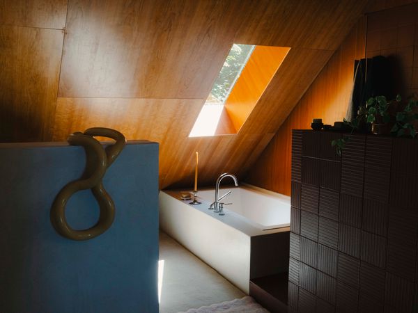 A large new bathroom is housed in an extension that allowed for the addition of an entryway and a small living room on the first floor, bringing the total square footage to 1,250. The skylight is one of several that dot the standing-seam metal roof.