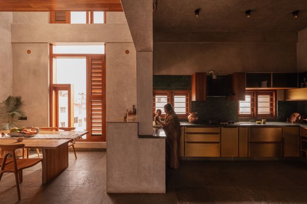 In the dining room, the Ibiza teak table and chairs are from Bali-based Lio Collection. The kitchen features wooden cabinetry, brass fittings, a forest green backsplash, and significantly more space than the family had before. 