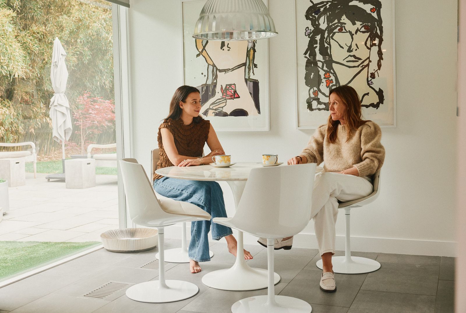 Emma Apple Chozick and her mom sit at a Saarinen Tulip table in their West Hartford, Connecticut, home.