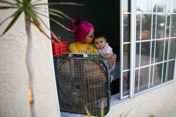 During a heatwave in Los Angeles in 2022, Karen Tapia cools off her daughter Jessalyn by a window with fan running on high because her home does not have air-conditioning.