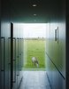 Discreet kitchen storage, which conceals the refrigerator, a wine cooler, the freezer, recycling, and cleaning materials, complements a view of one of the family’s five horses. Photo 6 of Wynant House modern home