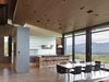 Modern home with Kitchen, White Cabinet, Wood Cabinet, Concrete Floor, Pendant Lighting, and Recessed Lighting. The dining area sits between the open concept kitchen and living room. Photo 7 of Wyoming Residence