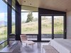 Modern home with Bedroom, Bed, Chair, Concrete Floor, Bench, and Recessed Lighting. The master bedroom shares in the floor-to-ceiling views, allowing symbiosis with the meadow outside. Photo 10 of Wyoming Residence