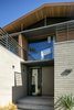 White brick creates a solid base for second-story wood paneling. Photo 2 of Cohen Residence modern home