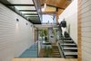 Upon entry, one is greeted by an impressive three-story atrium, accented by steel-framed glass floors and topped with pitched roof ceilings. Photo 3 of Cohen Residence modern home