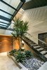 A living tree is stationed on the ground level, sprouting up through the multi-tier stairwell. Photo 4 of Cohen Residence modern home