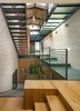 Glass is a prominent material used throughout the residence, seen from the very top of the structure in the form of expansive skylights and layered all the way down through the various levels of walkways. Not only does this articulate volume, but it also allows the natural light to stream through all levels of the home. Photo 10 of Cohen Residence modern home