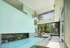 The indoor pool area opens up to the outdoor patio for year round swimming in the cold Toronto climate. An aquarium is nestled next to the interior pool wall. Photo 11 of Davis Residence modern home