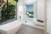 Intimate spaces, such as the master bathroom, are invited to enjoy the view with an extra-large window that overlooks the patio. Clever details make this functional; the glass becomes opaque when the bathroom lights are on to ensure privacy. Photo 8 of Glenhaven Residence modern home