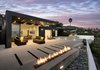 On the patio, an infinity pool overlooks the Pacific Ocean below. A low profile fire pit is paired with shorter succulents to maintain a direct view. Photo 12 of Glenhaven Residence modern home