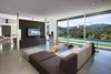 The open concept living room overlooks the pool outside and the mountains on the horizon. Interior walls never fully meet the ceiling, to keep a loft-like open floor plan. Photo 7 of Lima Residence modern home
