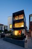 The front façade was redesigned with large openings that create a connection to the ocean views. Accordion style glass doors were installed on the lower floor to form an indoor-outdoor space with the front garden. The exterior palette is a subtle mix of smooth trowel stucco and honed limestone, emboldened with dark stained mahogany siding. Photo of Perrin Residence modern home