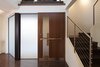 The public entry sequence pulls you through the front garden, leading to the main entry which sits on the side of the home. A custom designed walnut and stainless steel door opens into a two-story foyer. Photo 2 of Perrin Residence modern home
