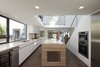By combining the existing two units, the new home now has increased length in the living spaces on the main floor. The layout is open for absolute connectivity of daily life. Custom white and walnut cabinetry in the kitchen create both expanse and composition. Photo 4 of Perrin Residence modern home