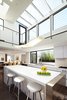 The central two-story kitchen is washed with light from multiple skylights, which also filter into the adjoining living and dining rooms. Photo 5 of Perrin Residence modern home