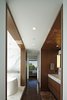Working within the narrow structure, the master bath occupies a passage into the bedroom with intricate architectural detail. Photo 6 of Perrin Residence modern home