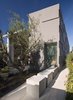 A single linear bar traverses the entire home along the property line and strings the interior spaces together, never breaking. It begins at the exterior entrance as a concrete partition running perpendicular to the front door. Photo 2 of Goodman Residence modern home
