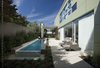 A slim pool and patio occupy the narrow side yard. A cantilevered carport is repurposed as an outdoor living room. Sliding glass doors open up for a seamless transition between the indoor and the patio. Photo 8 of Goodman Residence modern home