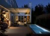 At night, the interior lights dramatically illuminate the floor-to-ceiling bookshelves. Photo 10 of Goodman Residence modern home
