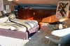 Modern home with Bedroom, Bed, Chair, and Rug Floor. Shown here is the master bedroom, which is nestled at the edge of the arched ceiling and is lit up by a red stained-glass window panel. Photo 5 of The Garcia House