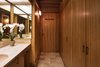 The only full privacy that exists in the main house—since everything is surrounded by glass—is in a cube that Liebermann placed in the center of the house. It’s seven feet tall, covered with a thin sheet of fiberglass to let the light stream in from a skylight, and holds two-and-a-half bathrooms. The woodworking here is done with a mahogany finish. Photo 9 of Liebermann House modern home